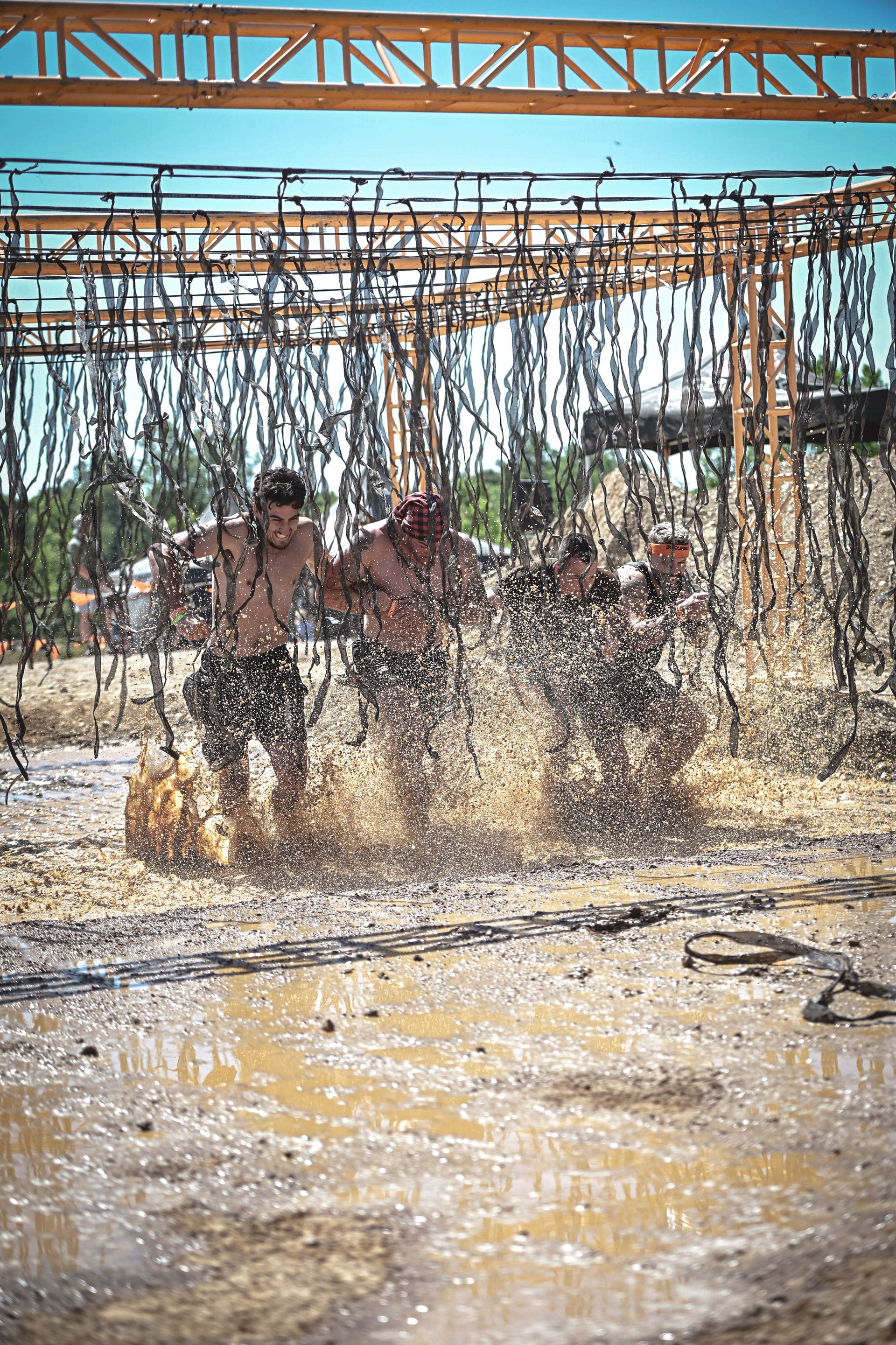 Sean and veterans charging through a mud obstacle together at Tough Mudder 2026