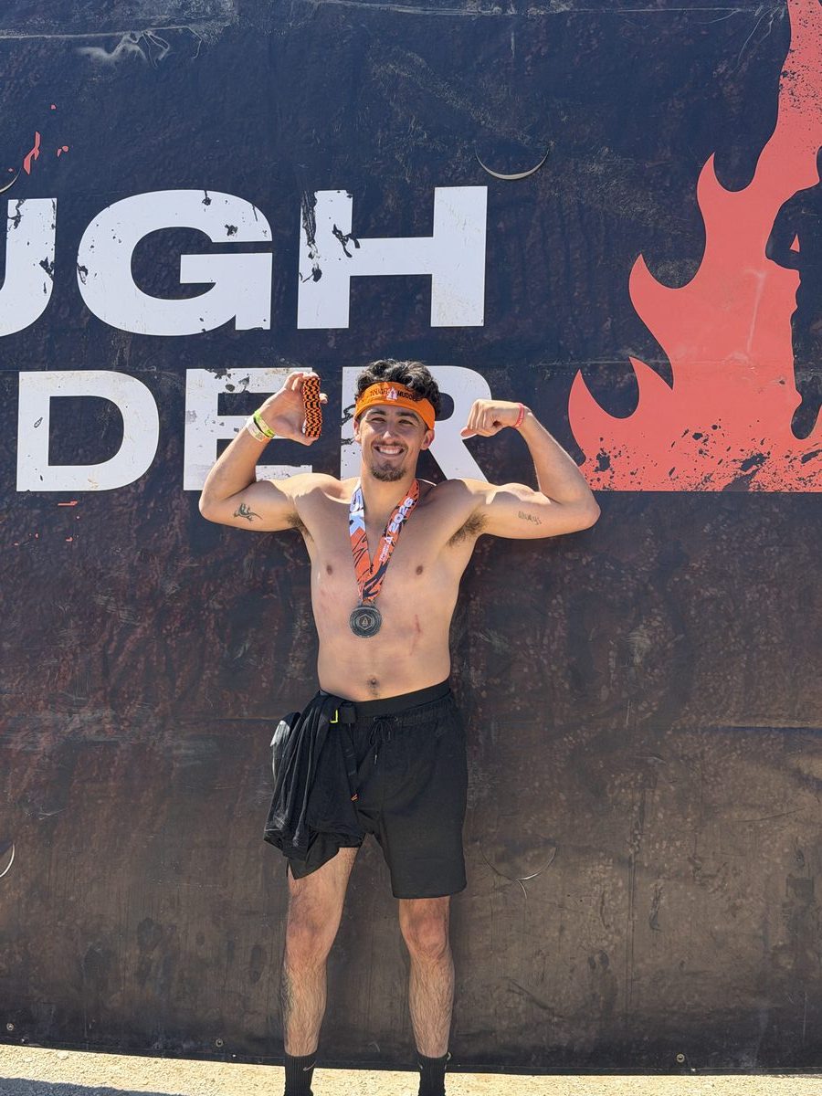 Sean Beyer at Tough Mudder 2026, holding honor coins with finisher medal