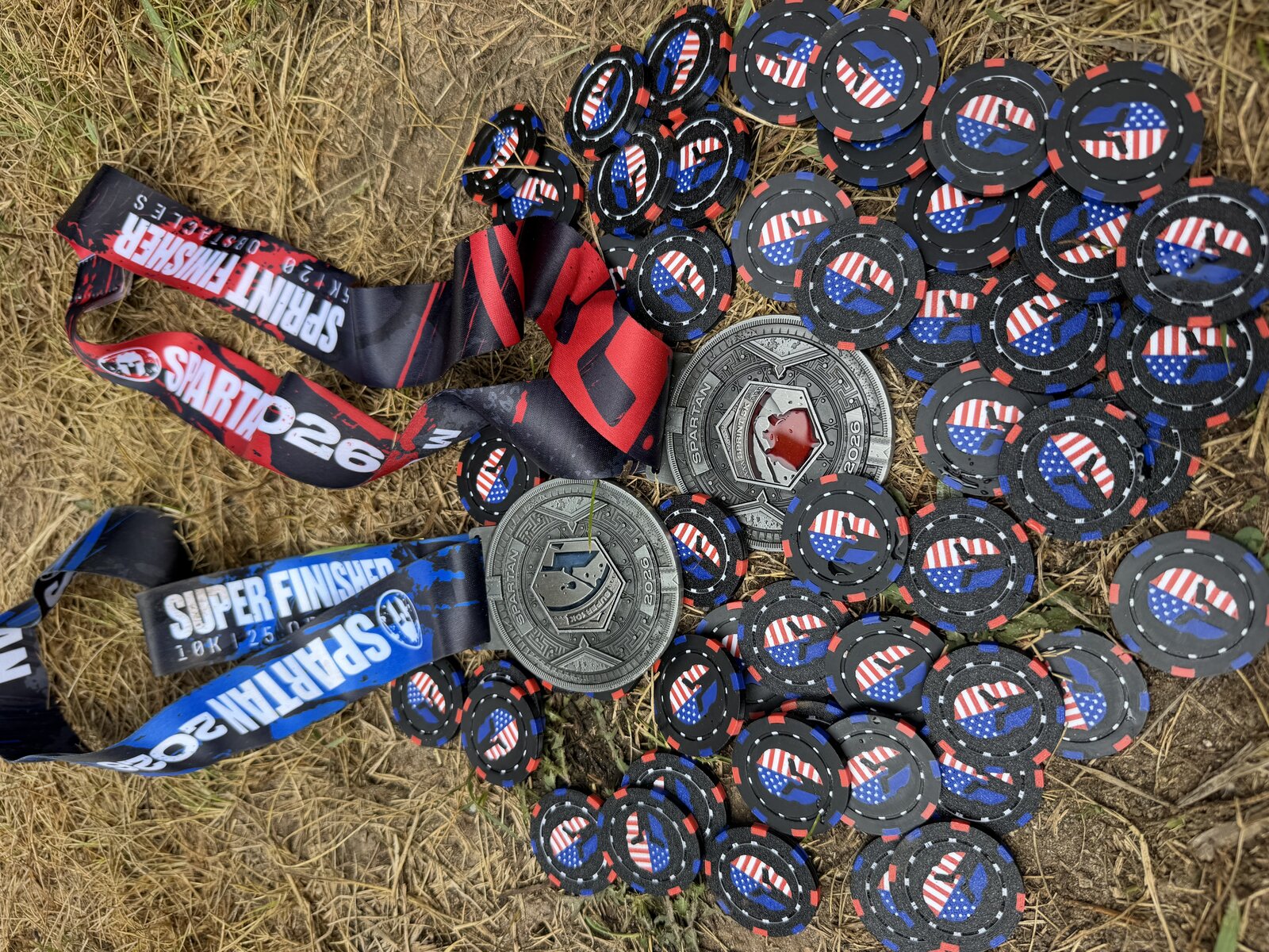 Honor coins carried through the Spartan 10K and 5K, laid out with the finisher medals